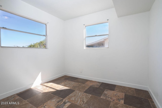 tiled empty room with a healthy amount of sunlight