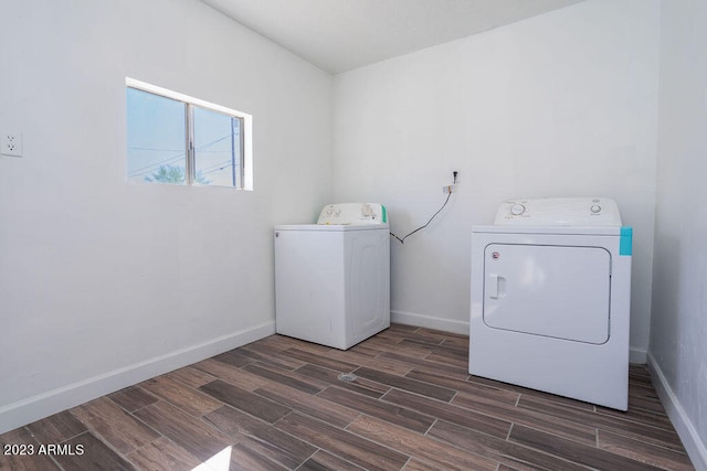 clothes washing area with separate washer and dryer and dark hardwood / wood-style flooring