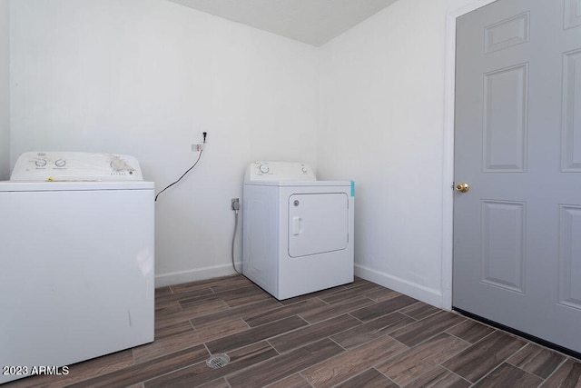 clothes washing area with electric dryer hookup, washing machine and dryer, and dark wood-type flooring