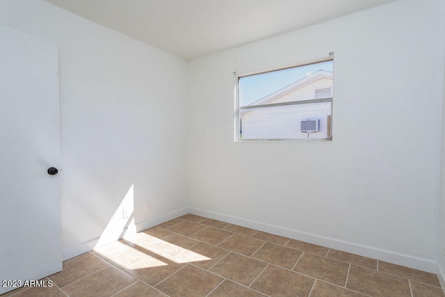 spare room featuring dark tile floors