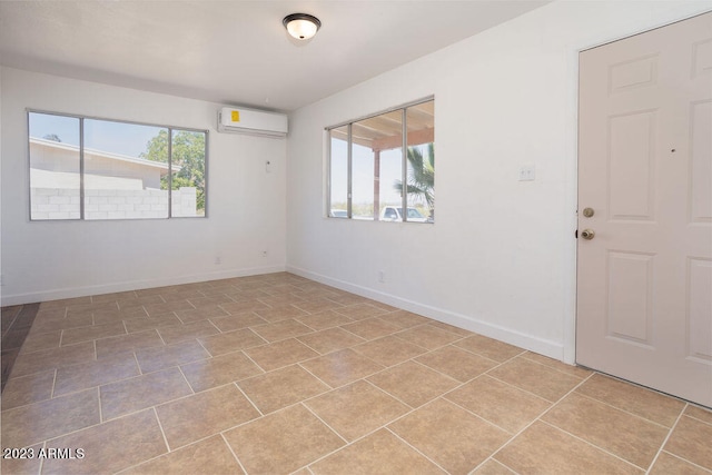 spare room featuring a wall mounted air conditioner and light tile floors