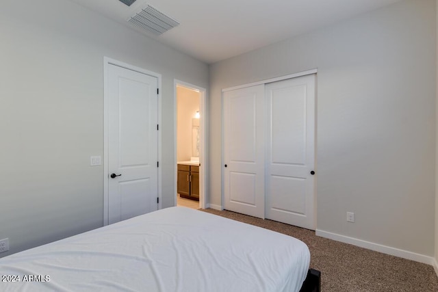 bedroom with visible vents, baseboards, light colored carpet, and connected bathroom