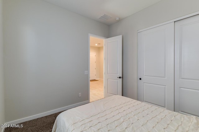 bedroom with a closet, carpet, and baseboards