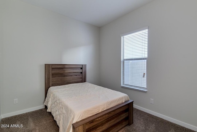 bedroom with baseboards and dark colored carpet