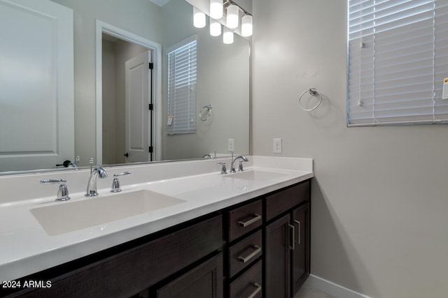 bathroom featuring double vanity, baseboards, and a sink