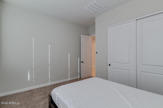 carpeted bedroom featuring a closet, baseboards, and visible vents