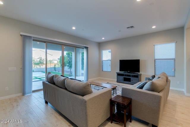 living area featuring light wood-style flooring, recessed lighting, visible vents, and baseboards