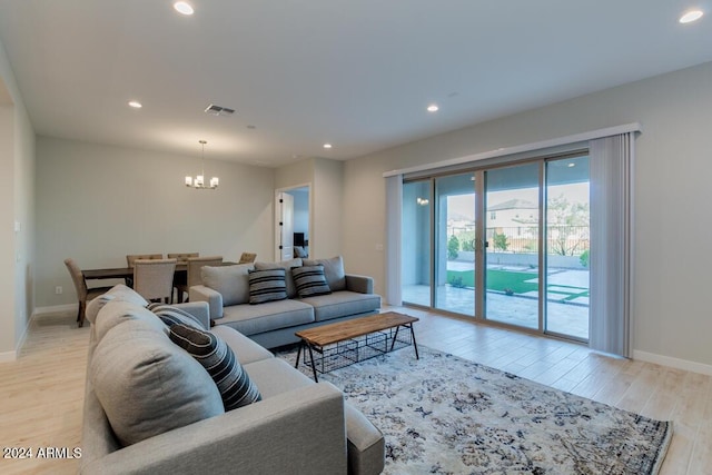 living area with visible vents, baseboards, recessed lighting, wood finished floors, and a notable chandelier