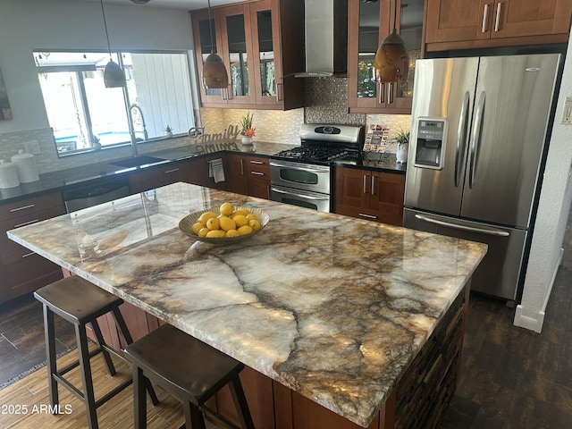 5802 E Spring Rd, Scottsdale, AZ 85254 - kitchen with appliances with stainless steel finishes, wall chimney exhaust hood, dark wood-style floors, a kitchen bar, and decorative backsplash