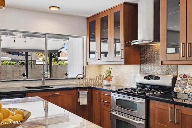 5802 E Spring Rd, Scottsdale, AZ 85254 - kitchen featuring range with two ovens, wall chimney range hood, dark stone countertops, a sink, and tasteful backsplash