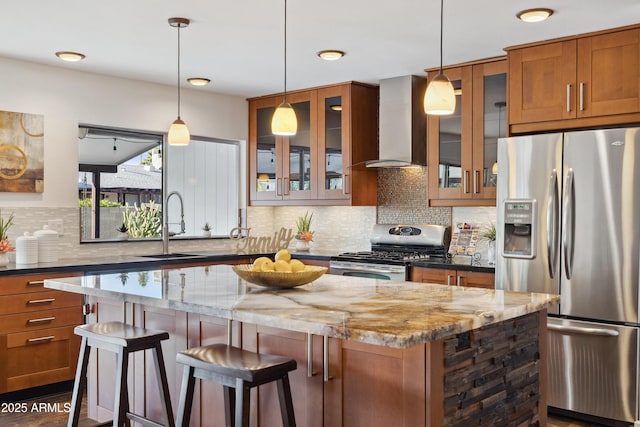 5802 E Spring Rd, Scottsdale, AZ 85254 - kitchen with stainless steel appliances, wall chimney range hood, a kitchen island, brown cabinetry, and a sink