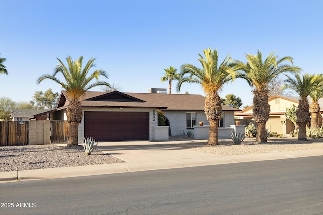 5802 E Spring Rd, Scottsdale, AZ 85254 - ranch-style house featuring a garage, concrete driveway, fence, brick siding, and a shingled roof