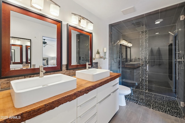 5802 E Spring Rd, Scottsdale, AZ 85254 - bathroom with a shower stall, ceiling fan, toilet, and double vanity