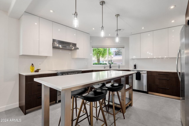 kitchen with a center island, decorative light fixtures, white cabinets, and dark brown cabinets