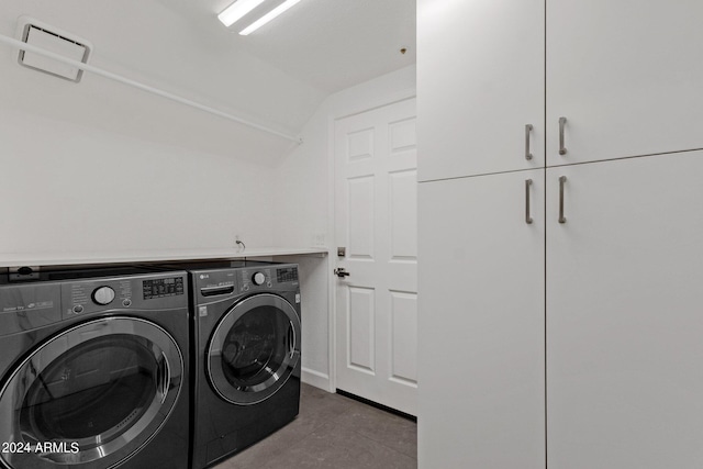 laundry room with washer and clothes dryer, cabinets, and tile floors