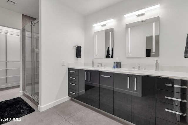 bathroom featuring tile floors, walk in shower, vanity with extensive cabinet space, and dual sinks