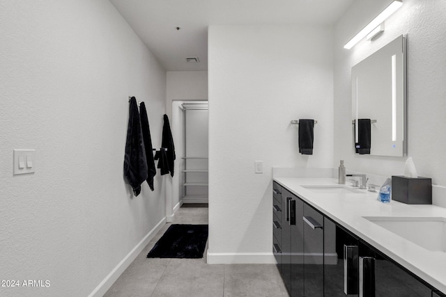 bathroom featuring oversized vanity, dual sinks, and tile floors