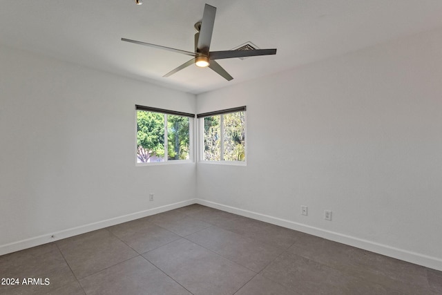 tiled empty room featuring ceiling fan