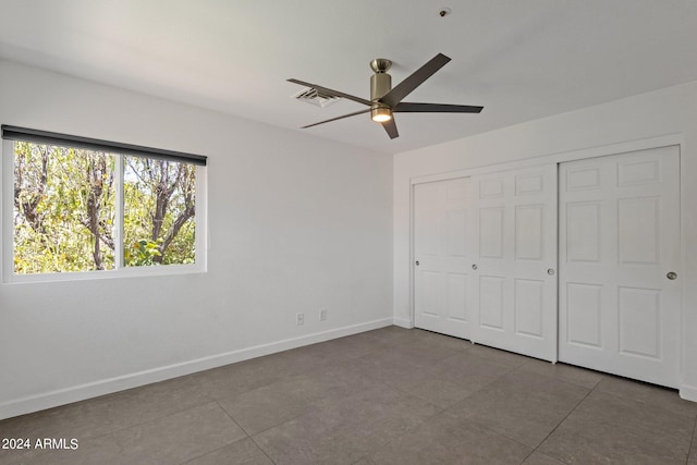 unfurnished bedroom featuring a closet, ceiling fan, and tile floors