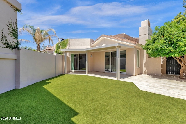 back of house with a patio and a yard