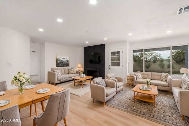 living area with light wood-style flooring, a fireplace, visible vents, and recessed lighting