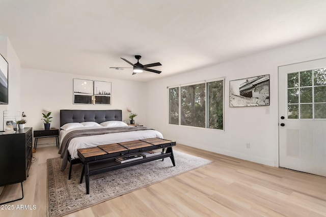 bedroom with light wood-style floors, ceiling fan, and baseboards