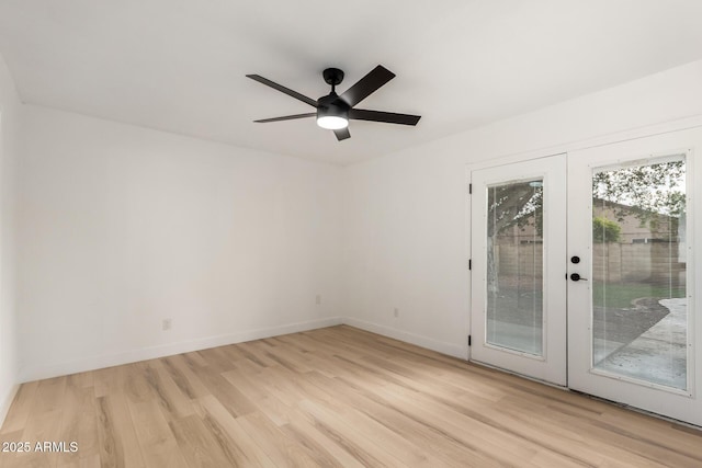 empty room with ceiling fan, french doors, light wood finished floors, and baseboards