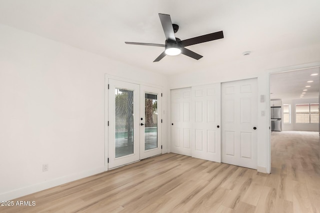 interior space with access to exterior, multiple windows, freestanding refrigerator, and french doors