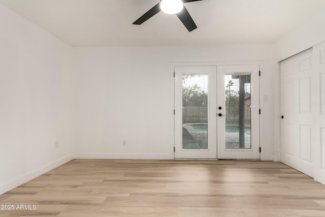 interior space with light wood finished floors, french doors, a ceiling fan, and baseboards