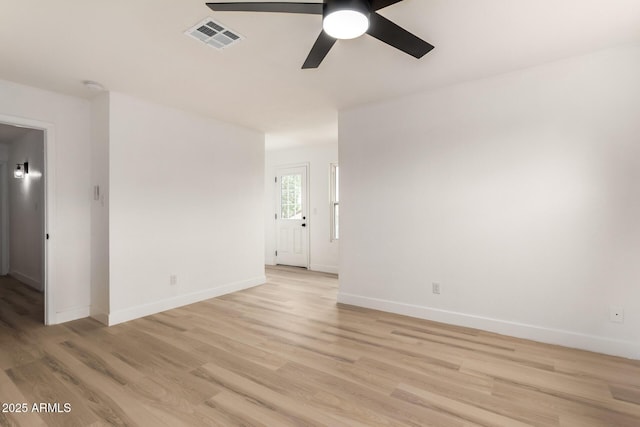 empty room with baseboards, visible vents, ceiling fan, and light wood finished floors