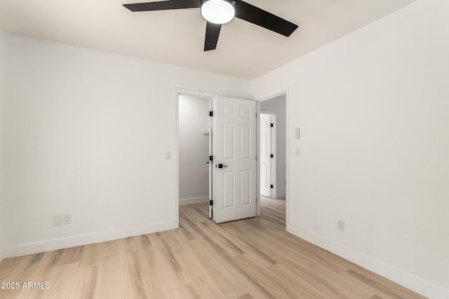 spare room featuring light wood-style floors, ceiling fan, and baseboards