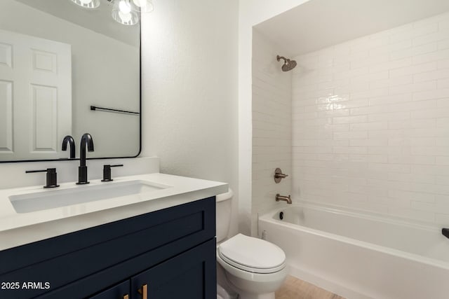 bathroom with a textured wall, shower / bath combination, vanity, and toilet