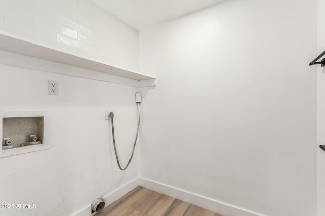 laundry area with baseboards, laundry area, washer hookup, and light wood-style floors