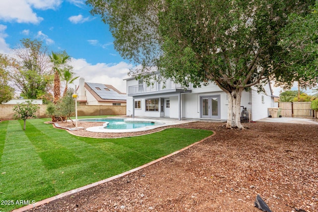 rear view of house with a fenced backyard, a patio, and french doors