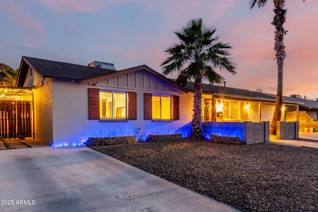 3643 E Friess Dr, Phoenix, AZ 85032 - view of front facade with concrete driveway, board and batten siding, a swimming pool, and a garage
