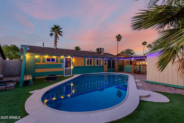 3643 E Friess Dr, Phoenix, AZ 85032 - pool at dusk featuring an outdoor pool, a patio area, and central air condition unit