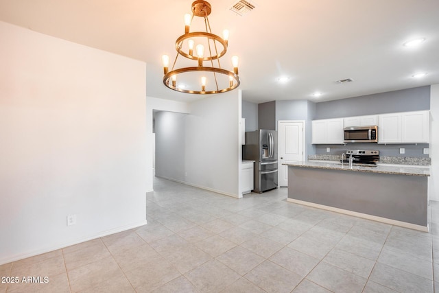 kitchen with an inviting chandelier, stainless steel appliances, light stone counters, white cabinets, and decorative light fixtures