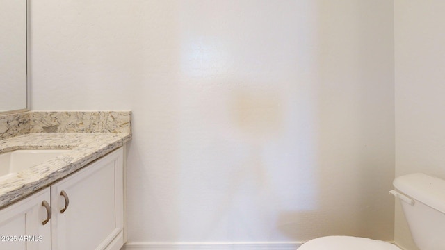 half bath featuring vanity and toilet
