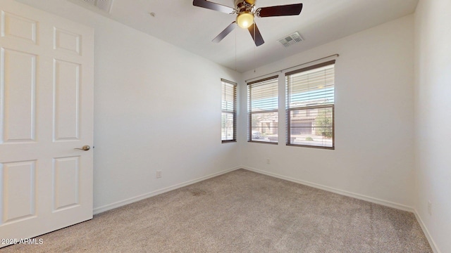 spare room featuring baseboards, visible vents, and light carpet