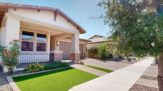 view of front facade featuring decorative driveway, a garage, stone siding, and stucco siding