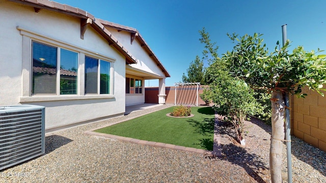 view of yard with a fenced backyard and central air condition unit