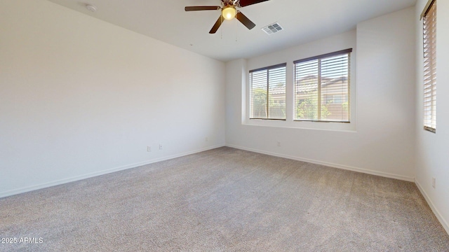 empty room with visible vents, baseboards, ceiling fan, and light carpet