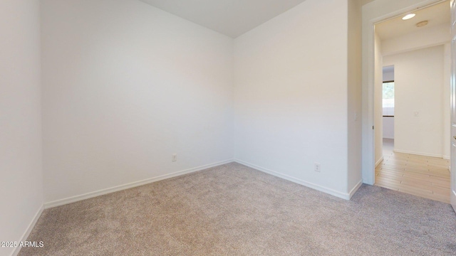 carpeted empty room with baseboards