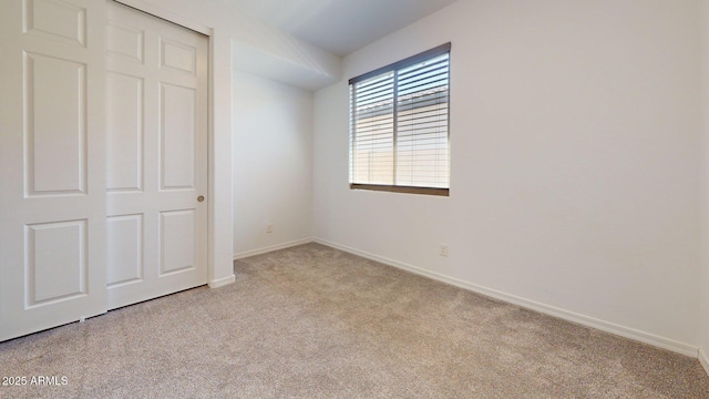 unfurnished bedroom featuring baseboards and light carpet