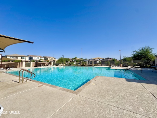 community pool with fence, a residential view, and a patio area
