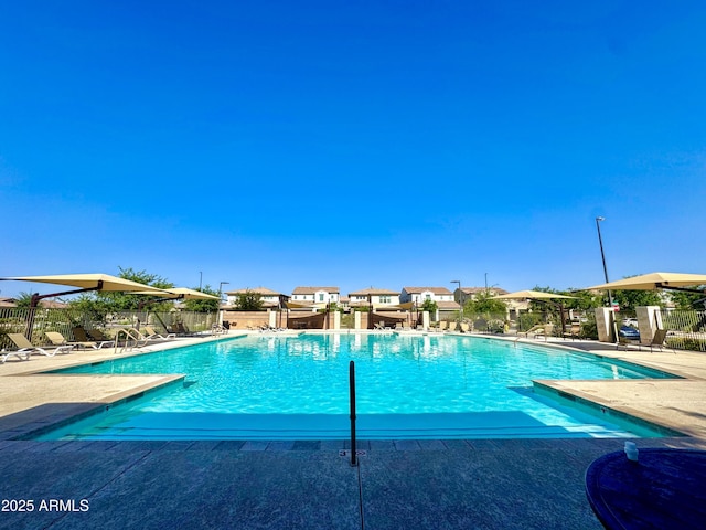 community pool with fence and a patio area