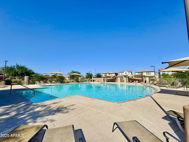 community pool with fence and a patio area
