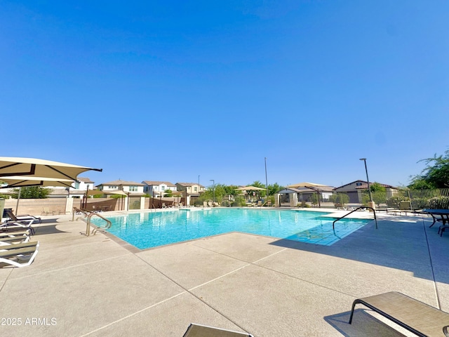 pool featuring fence, a patio area, and a residential view