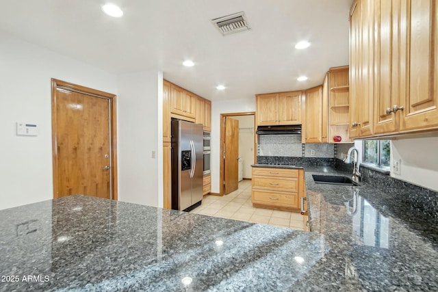 kitchen featuring appliances with stainless steel finishes, tasteful backsplash, sink, dark stone countertops, and light tile patterned floors