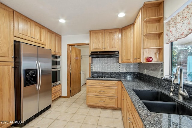 kitchen featuring appliances with stainless steel finishes, sink, decorative backsplash, and dark stone countertops